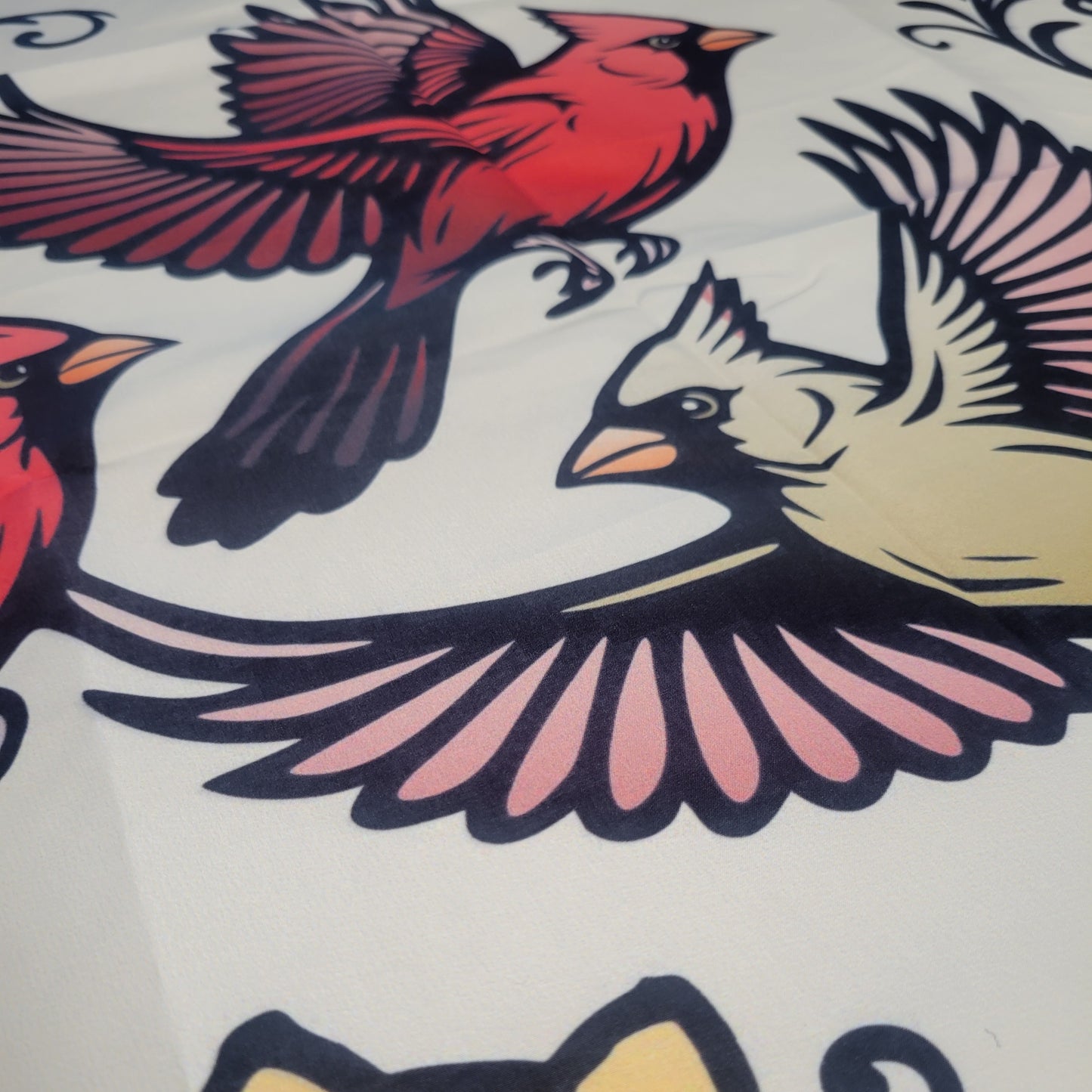 Bold, illustrated cardinals in flight on a beige background — vivid red males and a tan/yellow female with pink-accented wings in line art. Wall tapestry.