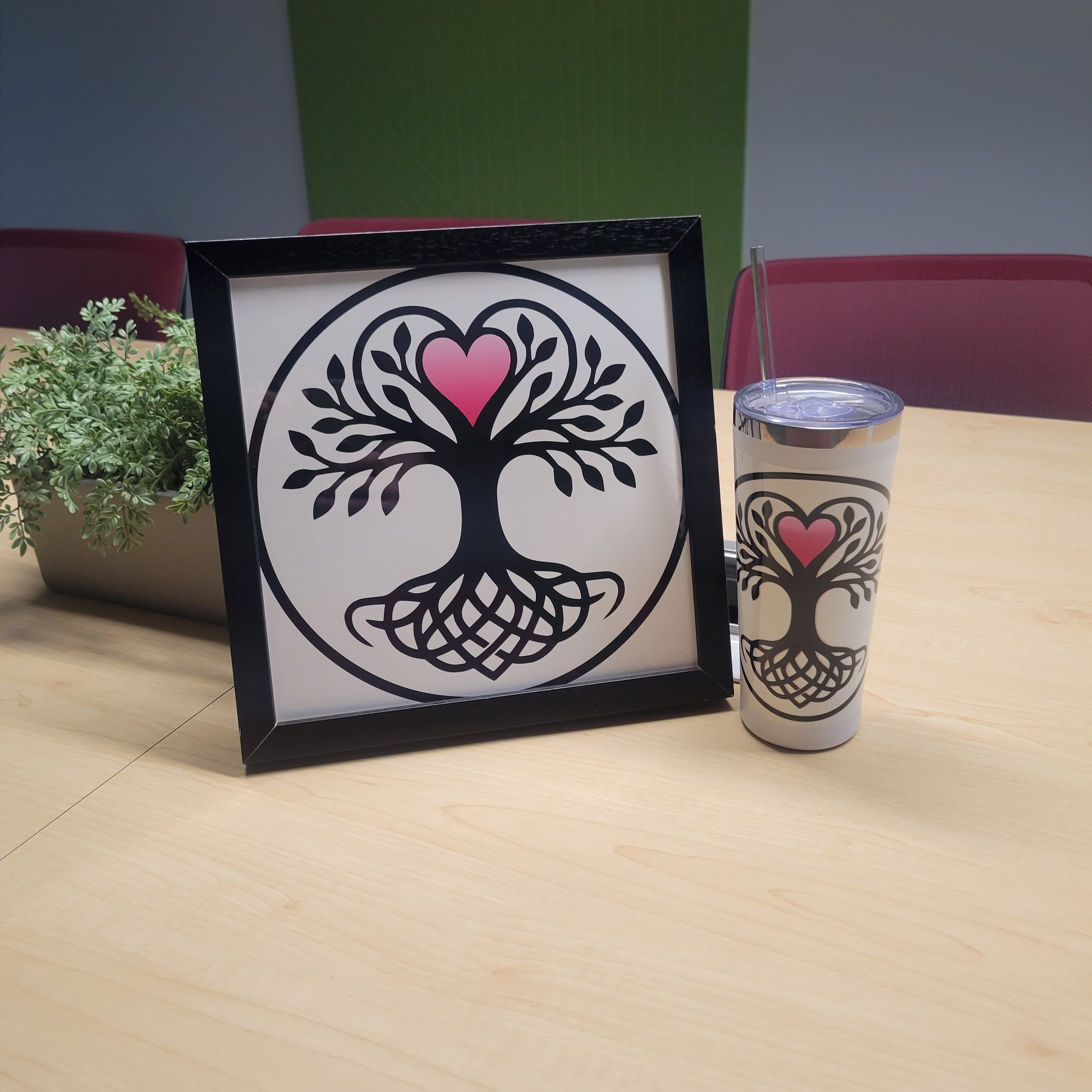 Black-framed wall art and matching tumbler featuring a Norse Tree of Life with interwoven knotwork roots and a pink heart canopy, black on white, circular design — framed wall art and tumbler set.