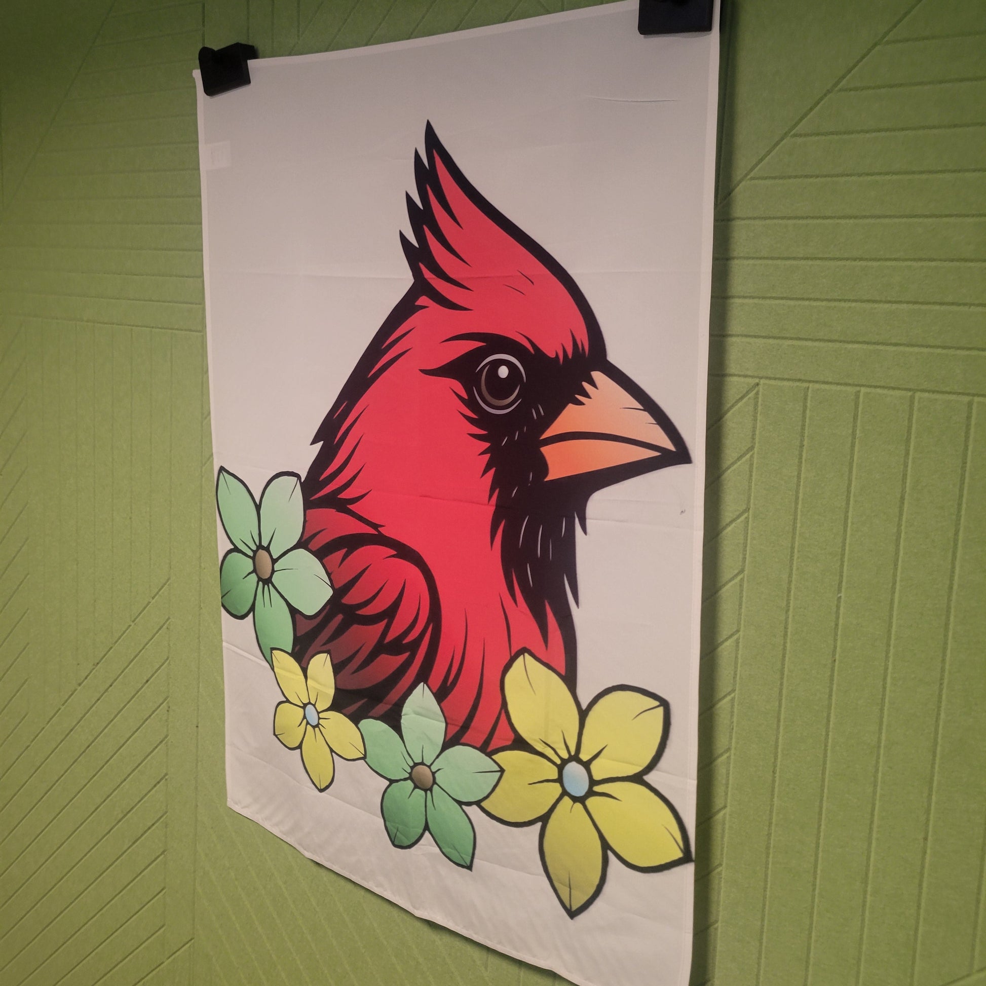 Bold graphic illustration of a red cardinal from the right side with black accents and an orange beak, surrounded by green and yellow flowers on a beige background, wall art poster.