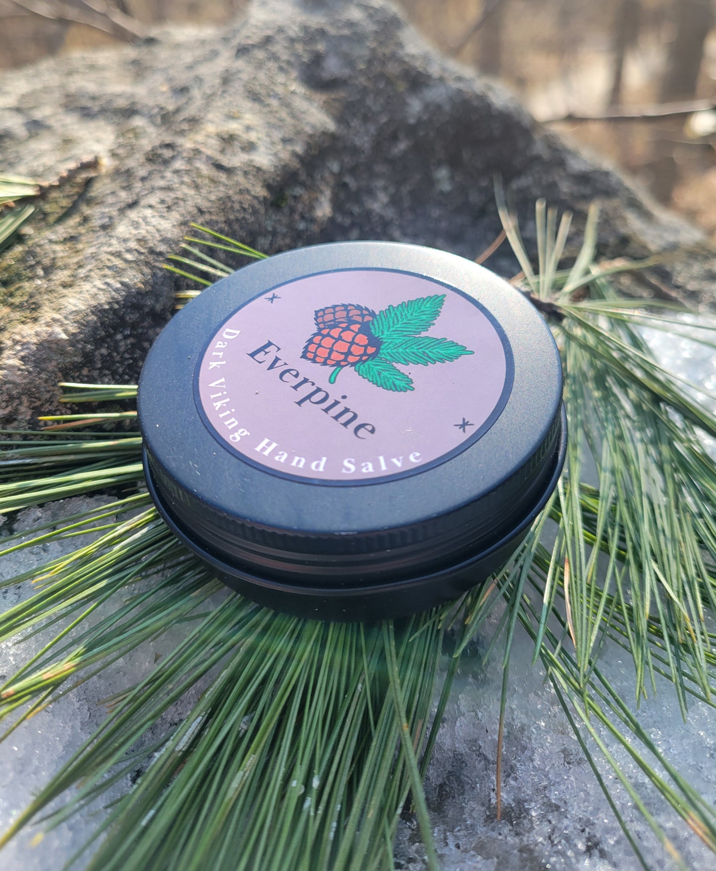 Hand salve container with 'Everpine' branding on a natural background