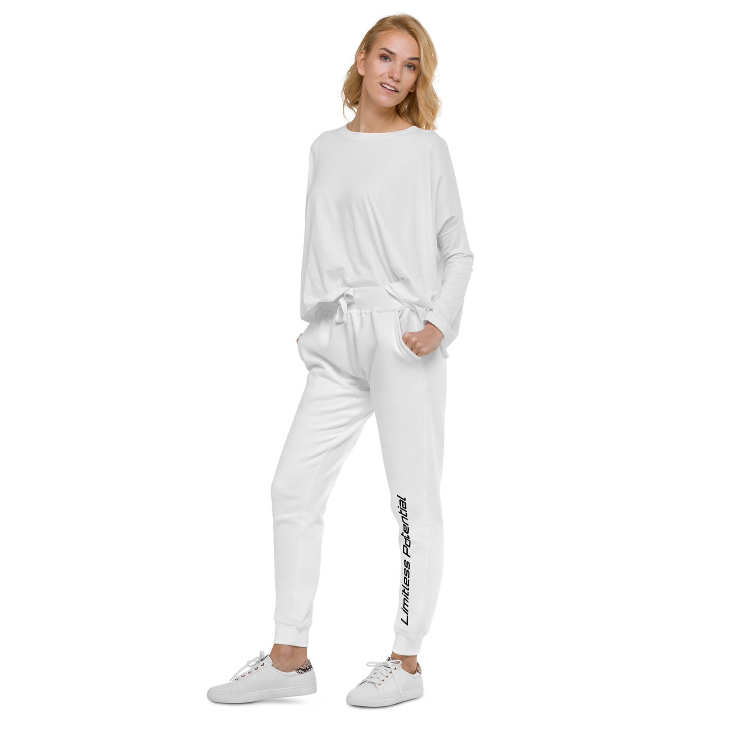 White jogger pants with "Limitless Potential" printed vertically along the lower left leg, paired with a matching white long-sleeve top on a female model, apparel.