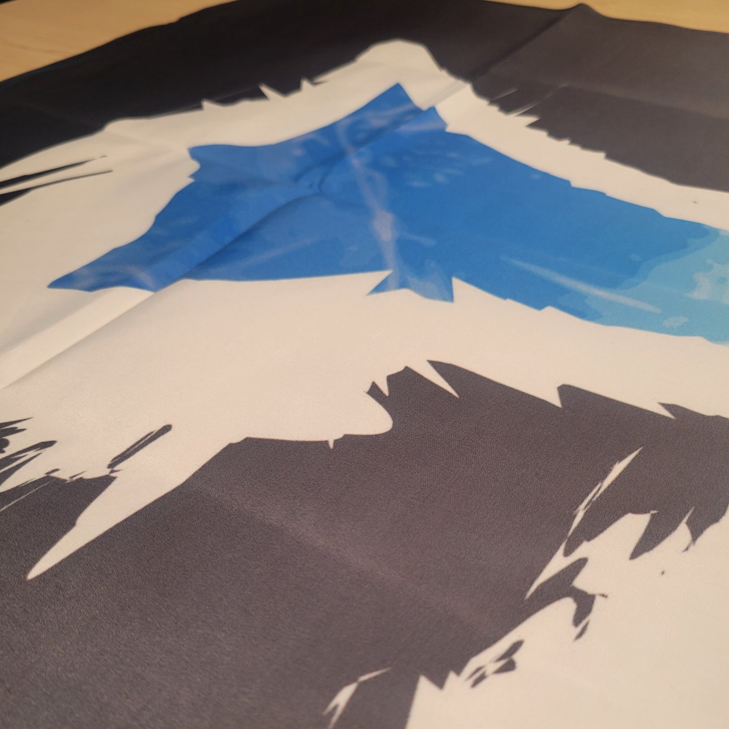 Bold graphic fantasy design in blue, white, and dark gray with jagged, angular brushstroke styling on fabric tapestry.