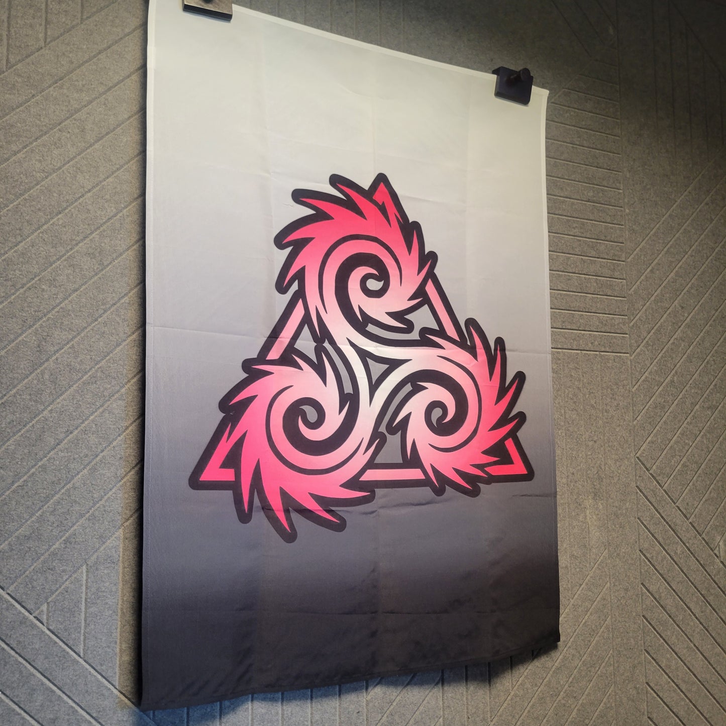 Hanging Triskelion symbol entwined as a triangle and fiery pink swirling edges on a white-to-black gradient background, wall tapestry.