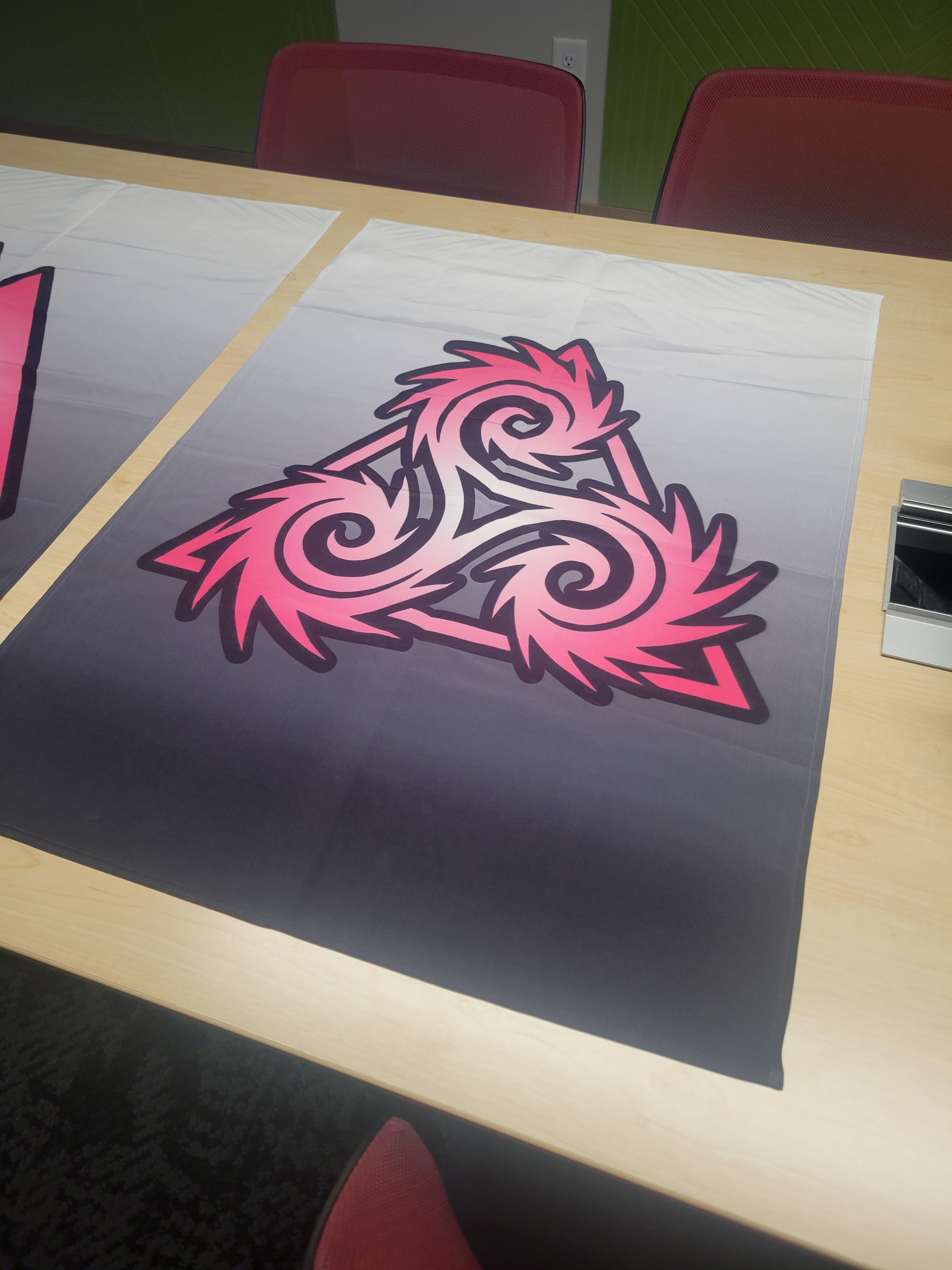 Pink and dark-outlined dramatic triskelion symbol on a white-to-charcoal gradient background, displayed flat on a table — wall tapestry.